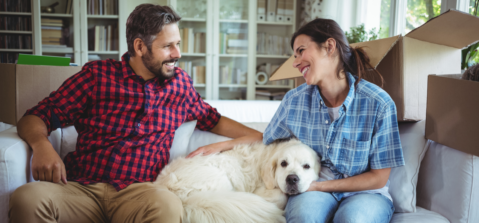two homeowners and dog on couch